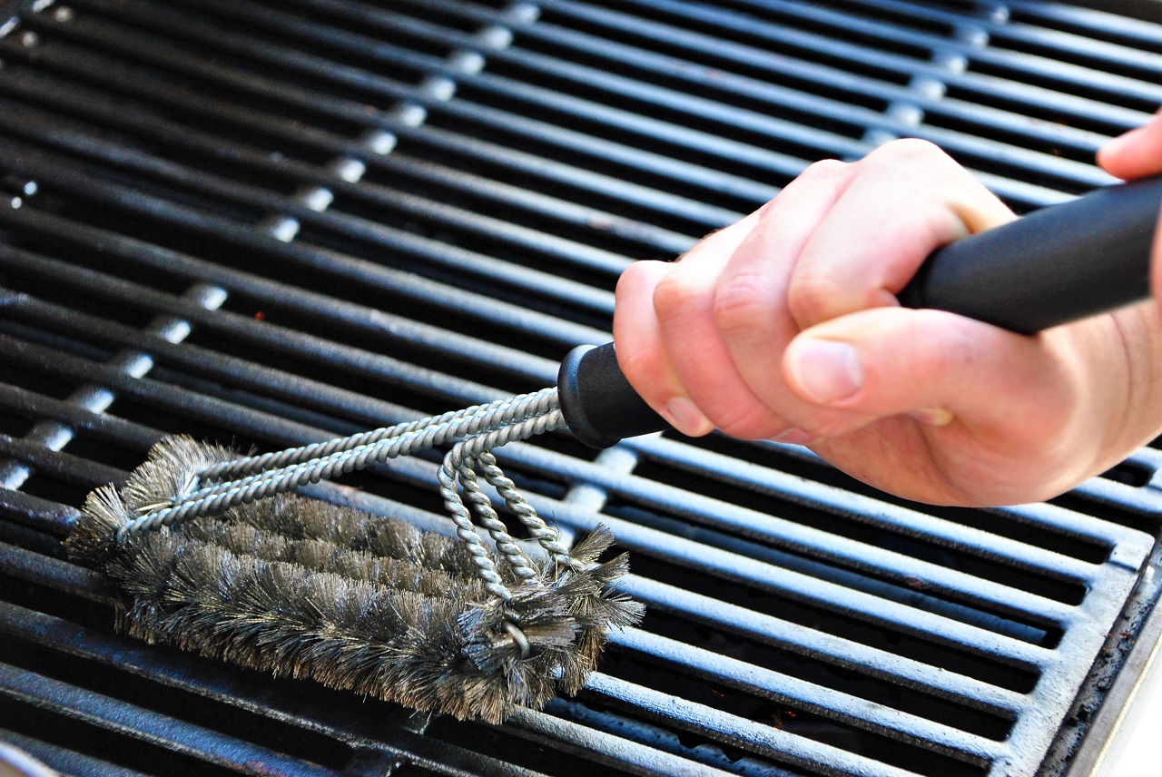 Cleaning-a-grill-at-a-summer-barbecue-party